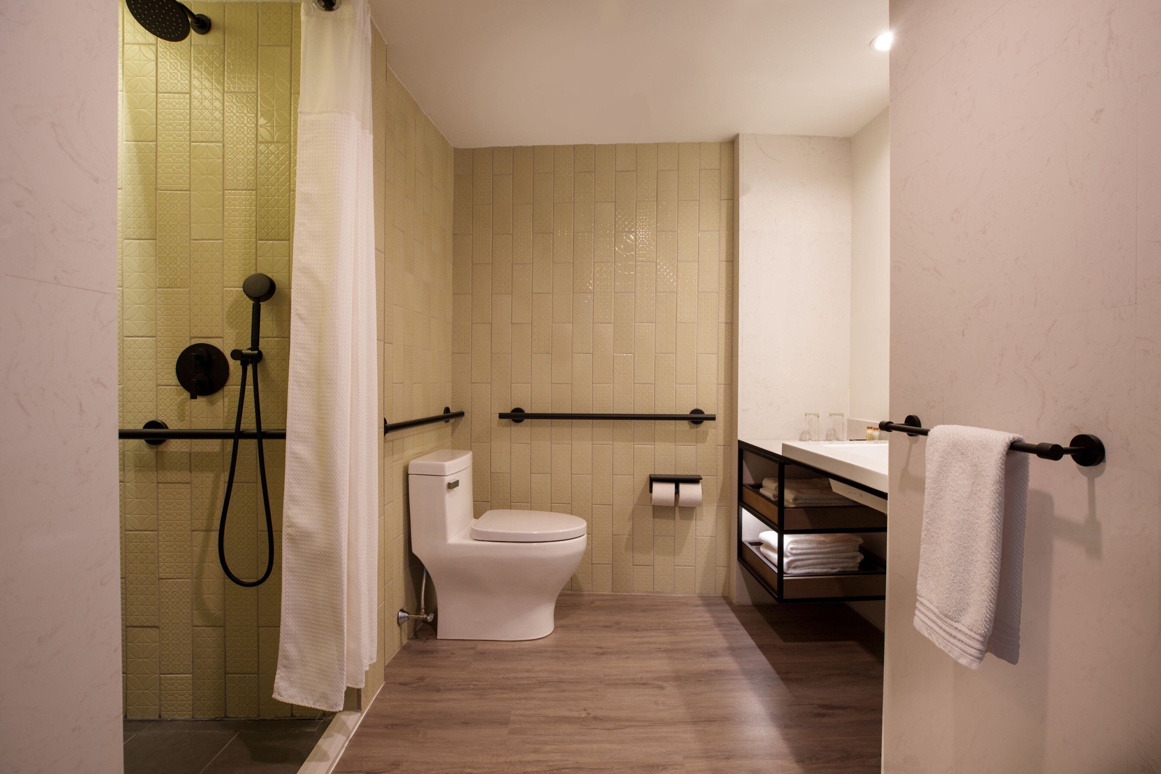 A bathroom with a shower, toilet, and sink.