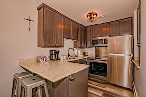 Enjoy cooking in this well-equipped kitchen with a coffee maker, microwave, oven, and refrigerator.