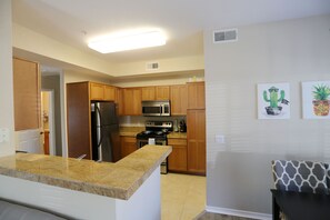 A kitchen with wooden cabinets, stainless steel appliances, and a granite countertop.
