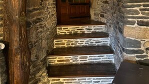Una escalera de piedra que conduce a una puerta de madera con paneles de vidrio.