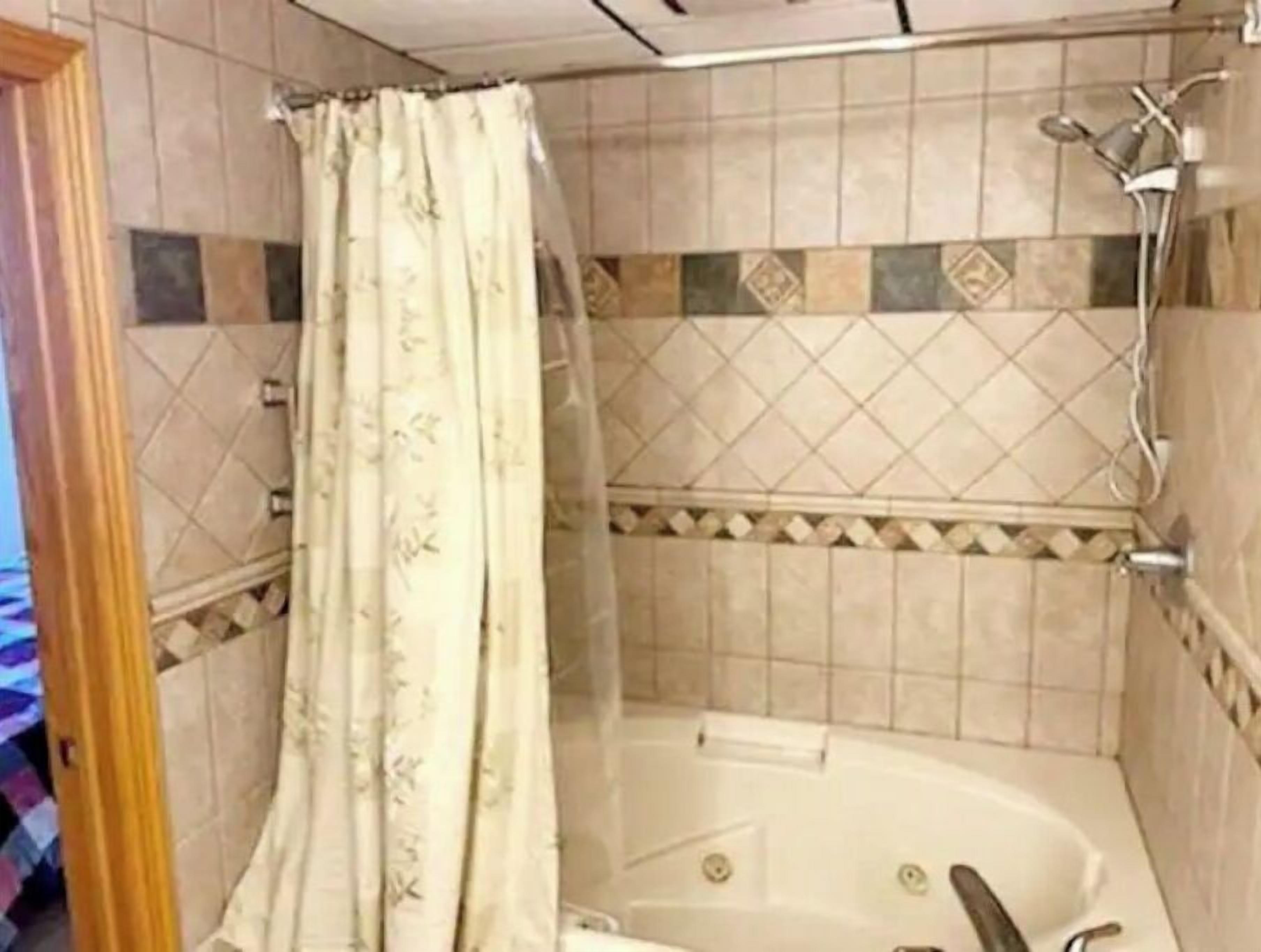 Bañera con ducha, toallas, papel higiénico