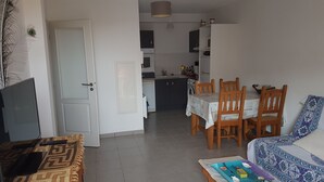 Ein kompakter Wohnbereich mit Essbereich, Küche und einer Couch.