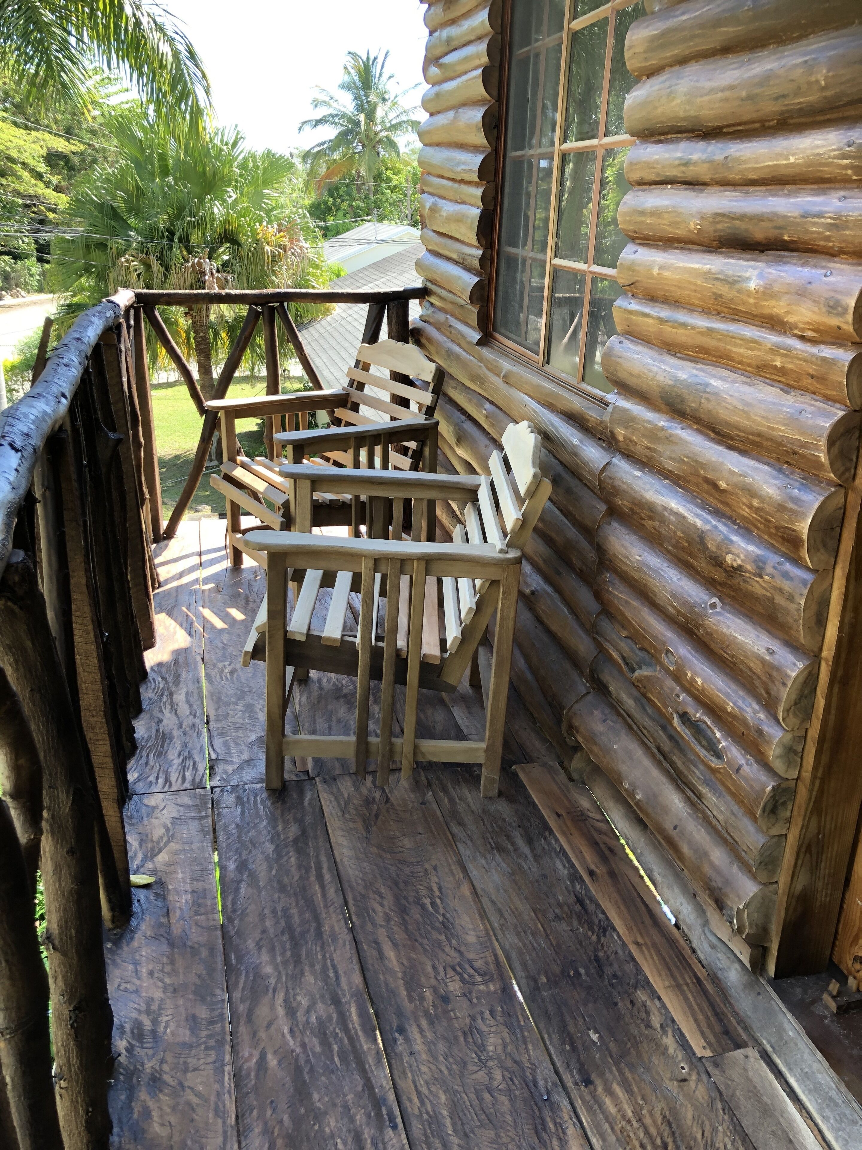 A wooden deck with a wooden bench and a table, surrounded by a wooden fence.