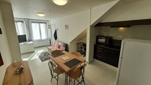 Een knus woongedeelte met een eethoek, kitchenette en een zithoek.