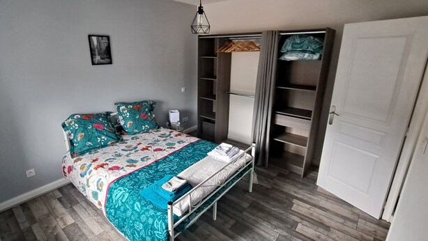 Een slaapkamer met een bed, een kledingkast en een inbouwkast.