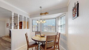 A dining area with a round table, four wooden chairs, a chandelier, and a decorative wall piece. - NEW Updated, Private 3/2 Home(King)Near Balloon Fiesta Park, Quiet Neighborhood! (Albuquerque)