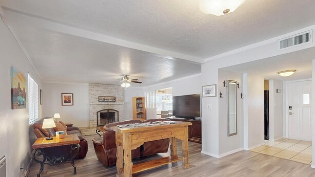A living room with a fireplace, a television, and a dining table. - NEW Updated, Private 3/2 Home(King)Near Balloon Fiesta Park, Quiet Neighborhood! (Albuquerque)