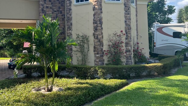 A house with a stone facade, a garage, and a well-maintained lawn.