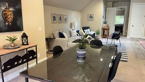 A modern dining area with a glass table, black chairs, and a decorative vase.