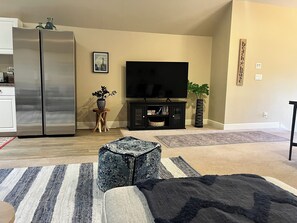 Relax in this stylish living room with a large flat-screen TV, dining table, and comfortable seating.