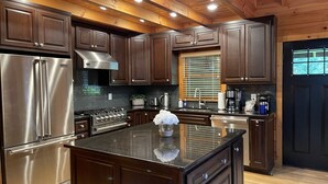 Una cocina moderna con armarios de madera oscura, electrodomésticos de acero inoxidable y una isla central.