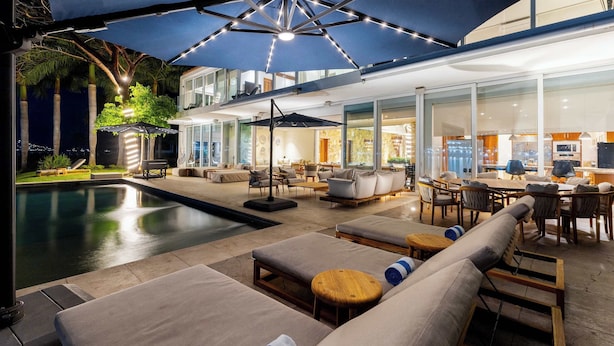 A poolside area with lounge chairs, umbrellas, and a dining area with tables and chairs. - Casa Luna del Mar - Private Pool & Beach, FastWifi (Puerto Vallarta)