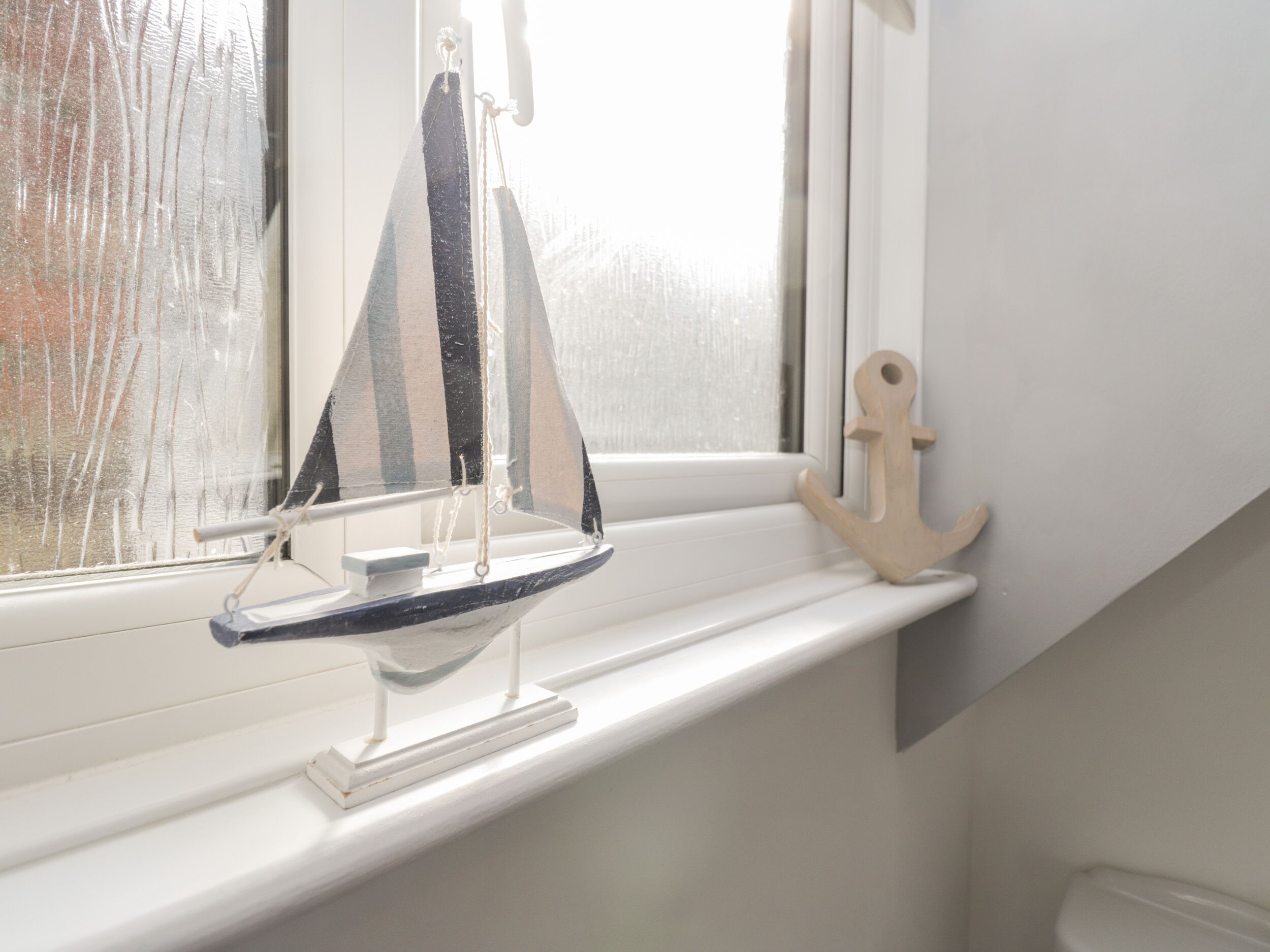 A sailboat model on a windowsill.