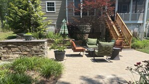 Een terras buiten met stenen muren, plantenpotten en tuinmeubilair.