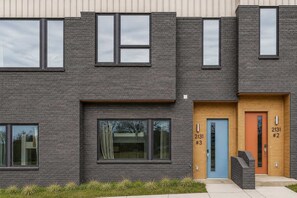 A modern building with three distinct entrances, each marked with a unique number.