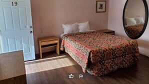 A bedroom with a bed, a nightstand, a mirror, and a door. - Napp Inn Motel (Rock Falls)