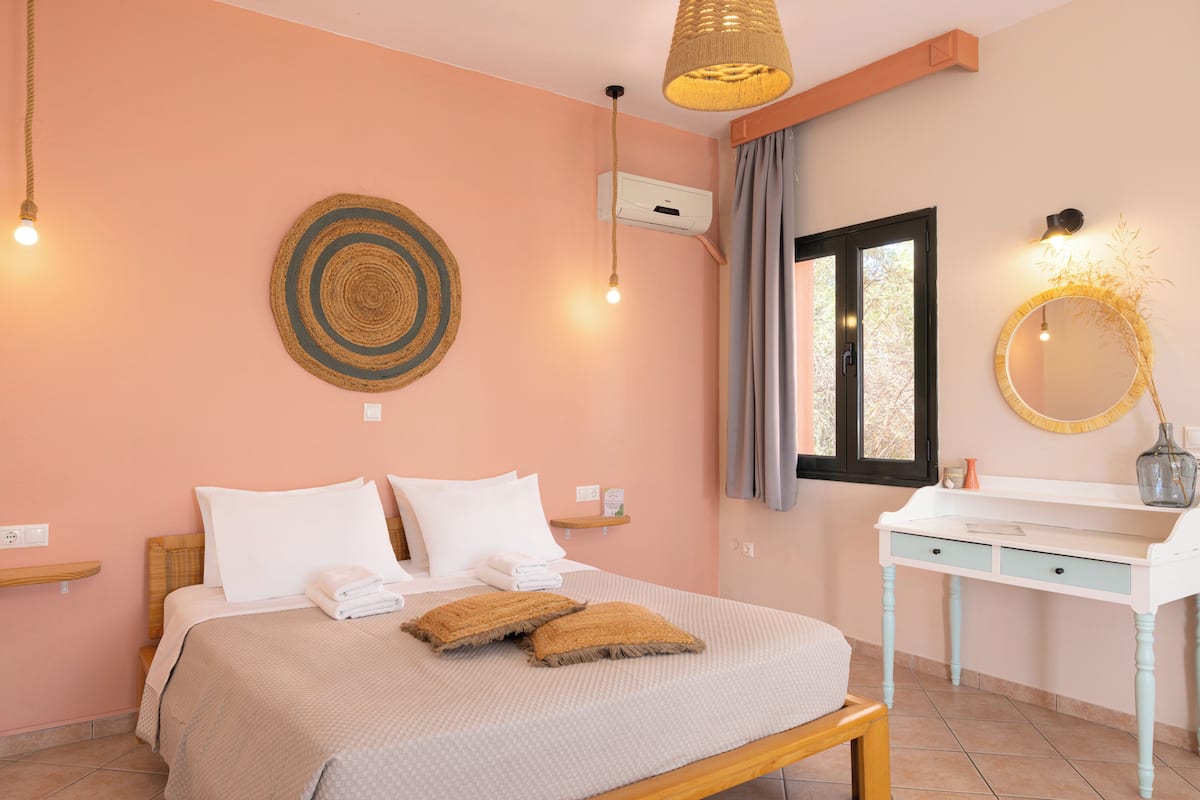 A bedroom with a bed, bedside table, and a mirror.