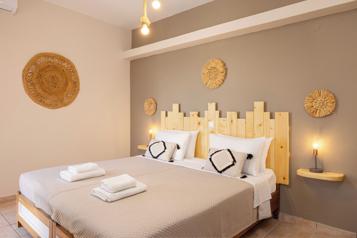 A neatly made double bed with a wooden headboard, two bedside tables with lamps, and decorative wall art.