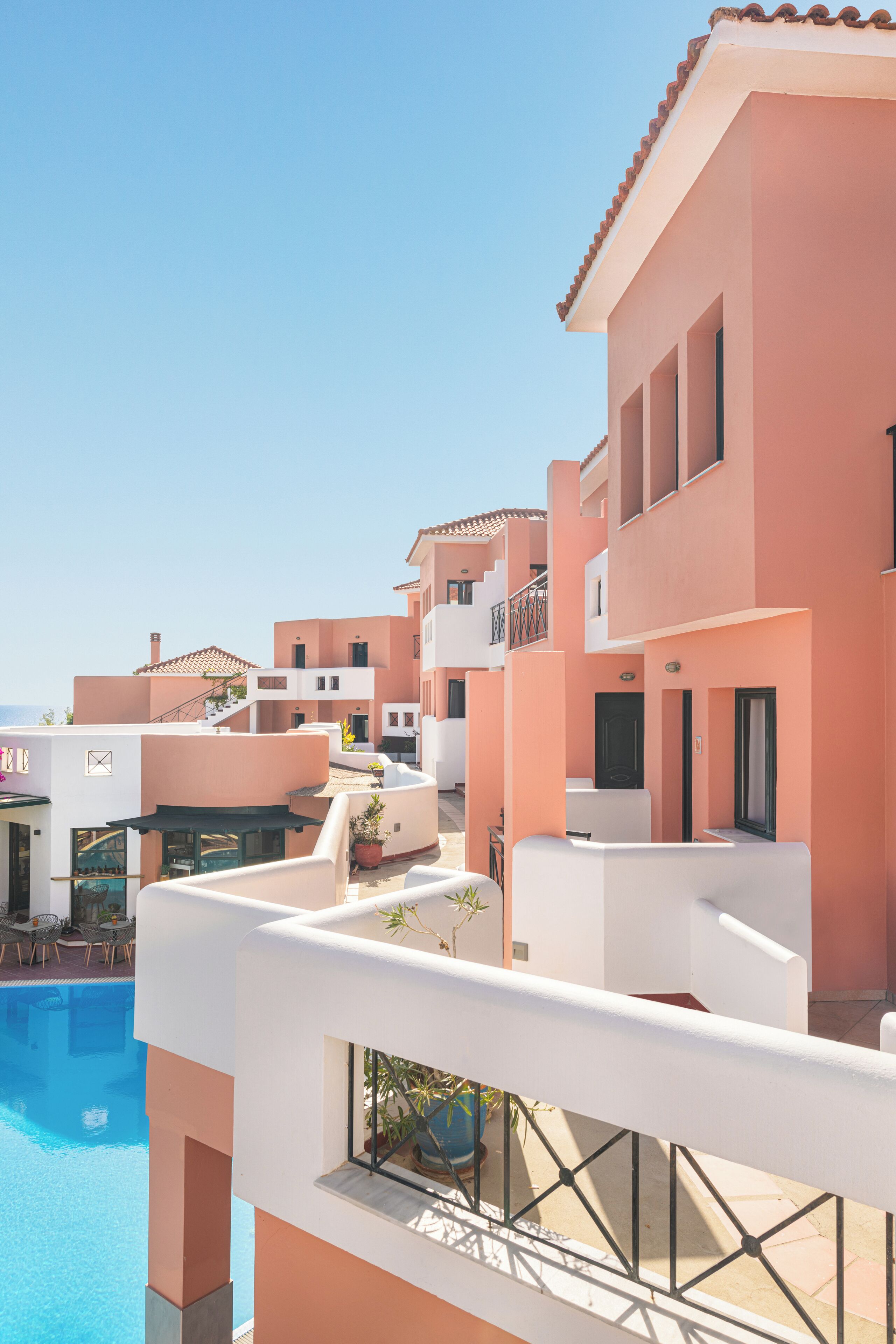 A resort with multiple buildings, a swimming pool, and outdoor seating areas.