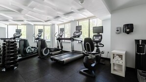 A gym with treadmills, elliptical machines, and weight racks. - 2500 Penn, a Placemakr Experience (Washington)