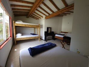 A room with two bunk beds, a desk with a mirror, and a chair. - Hostería Brisas del Río (Marinilla)
