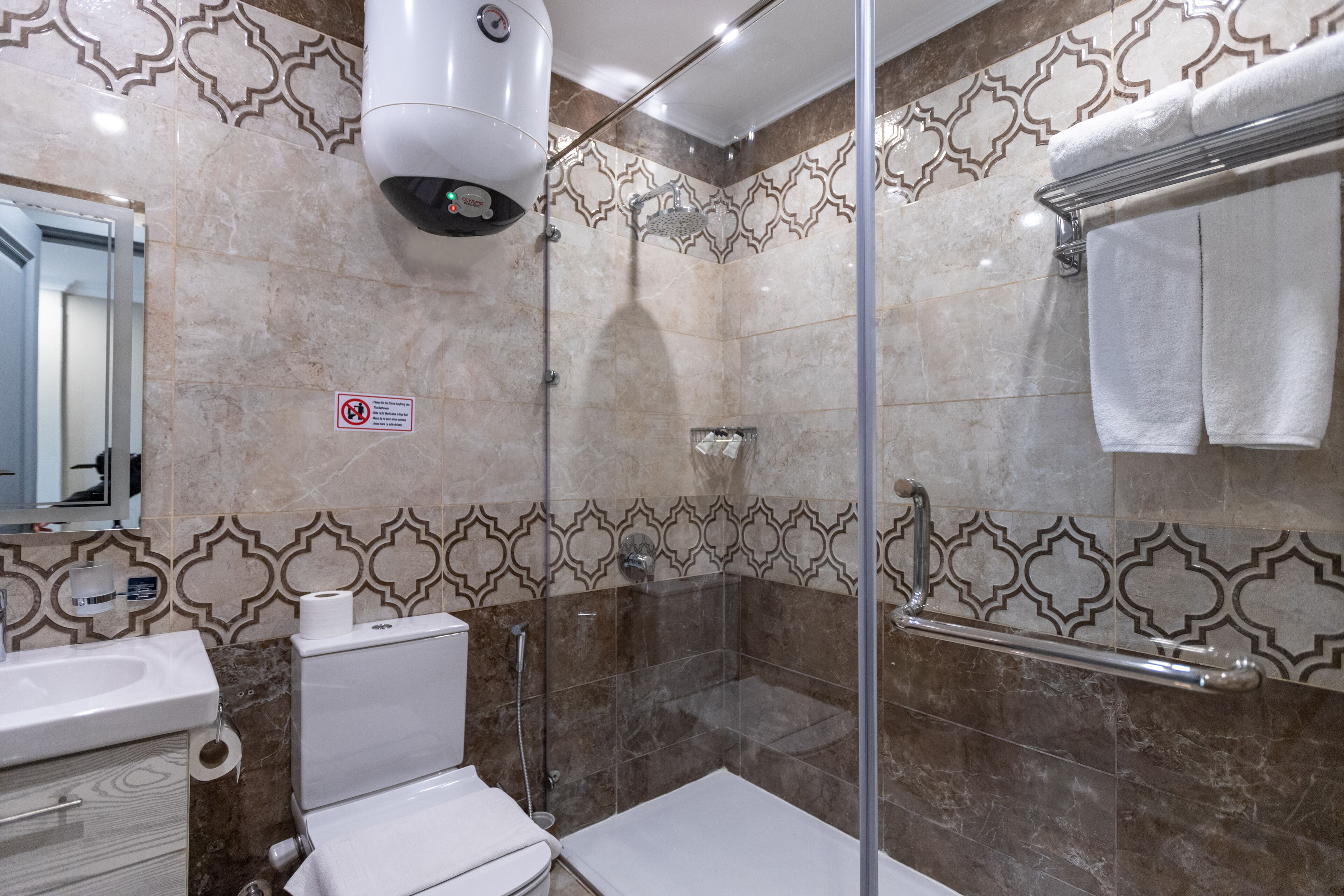 A bathroom with a shower, toilet, and sink.