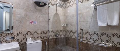A bathroom with a shower, toilet, and sink.