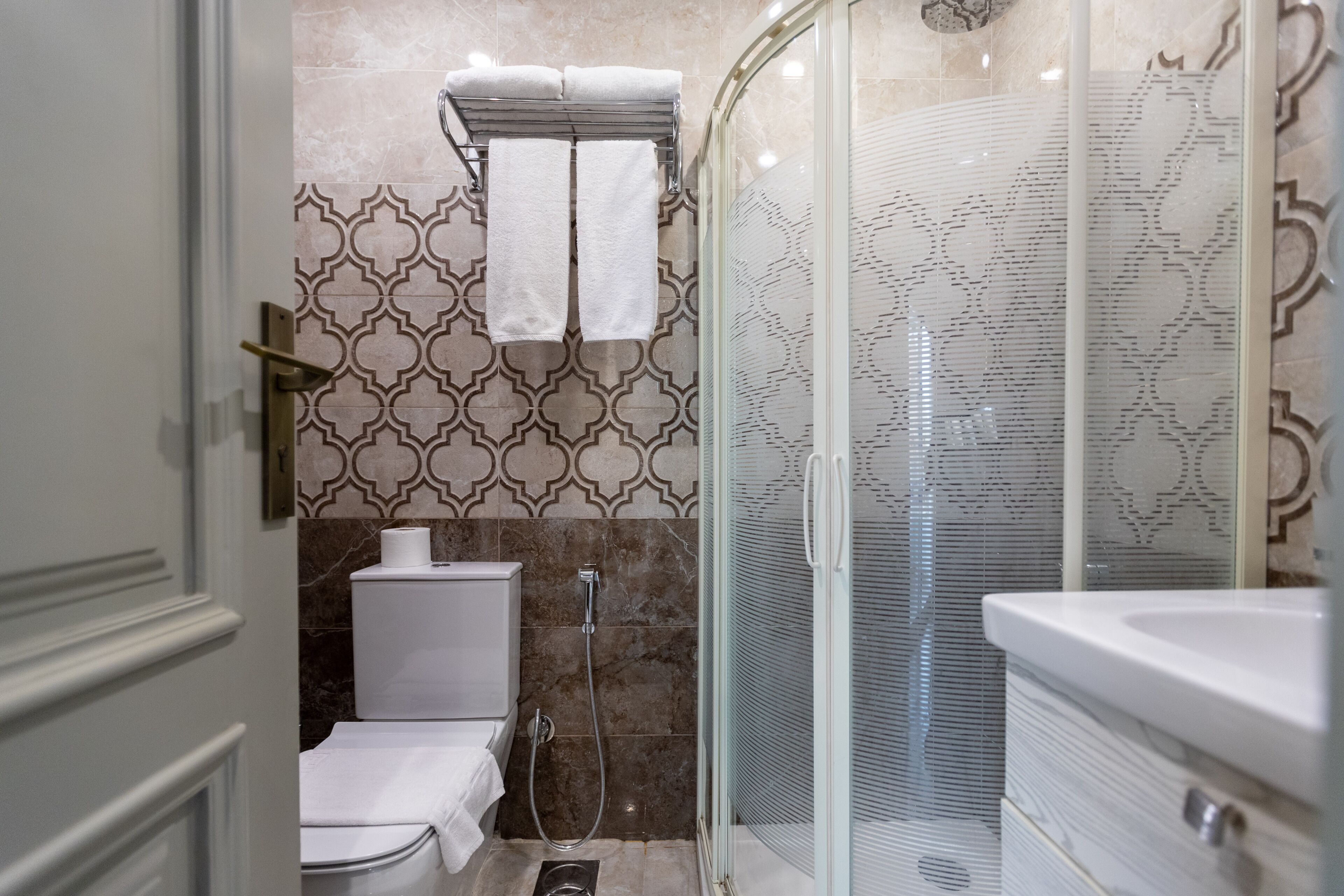 A modern bathroom with a toilet, shower, and sink.