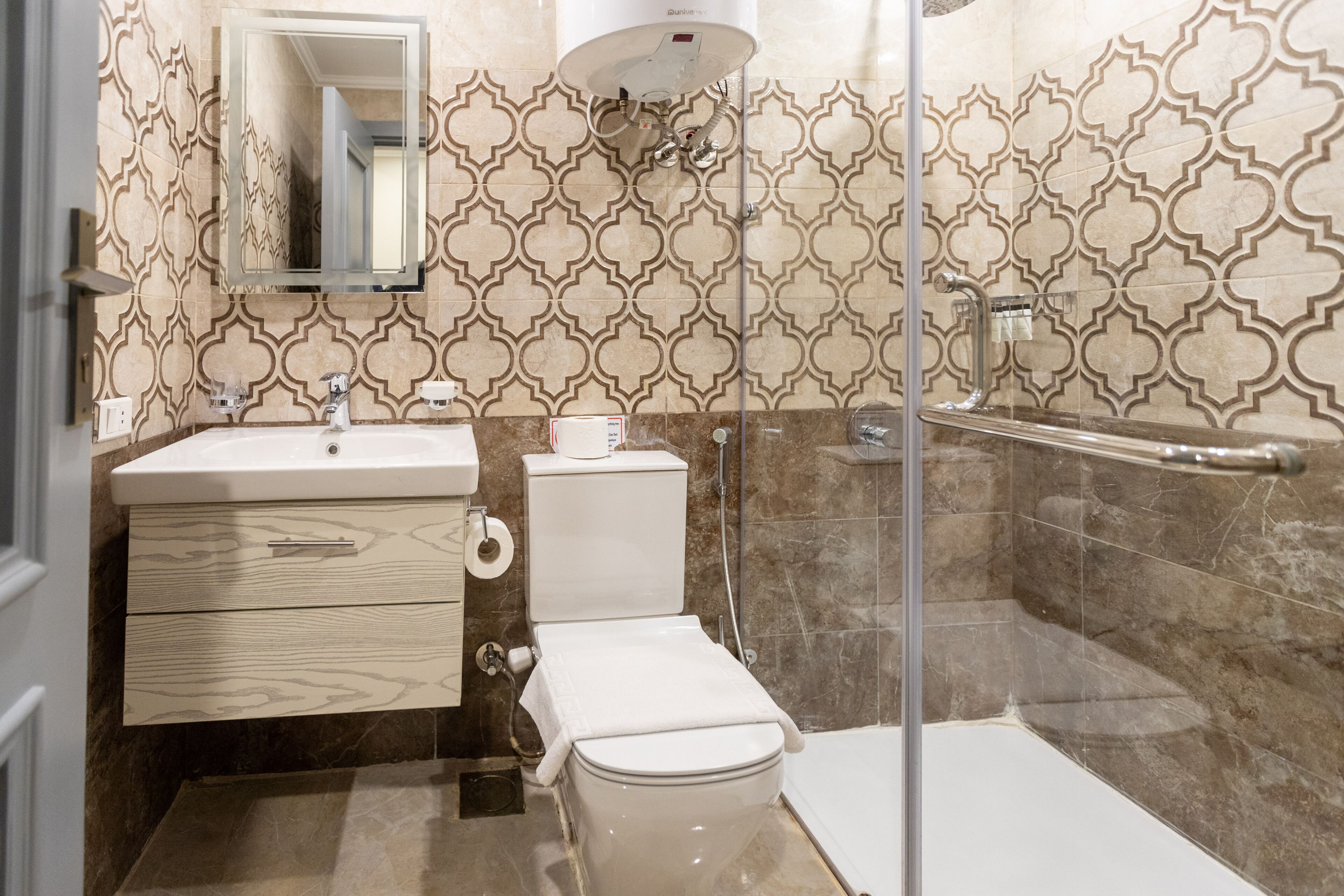 A bathroom with a toilet, sink, and shower area.