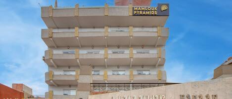 A hotel with multiple floors and a sign for 'Mamlouk Pyramids Hotel'.