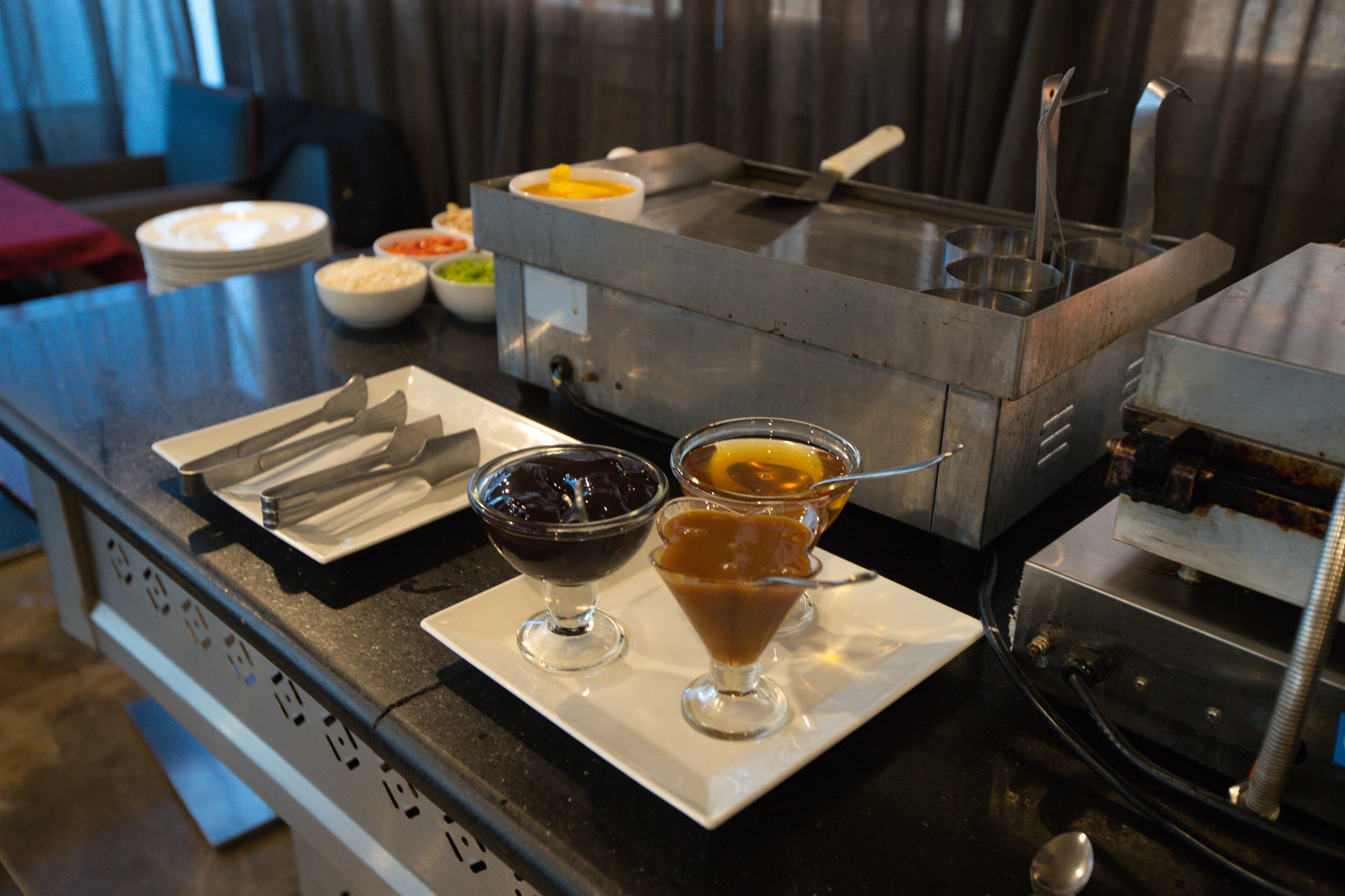 A buffet setup with various dishes and utensils.