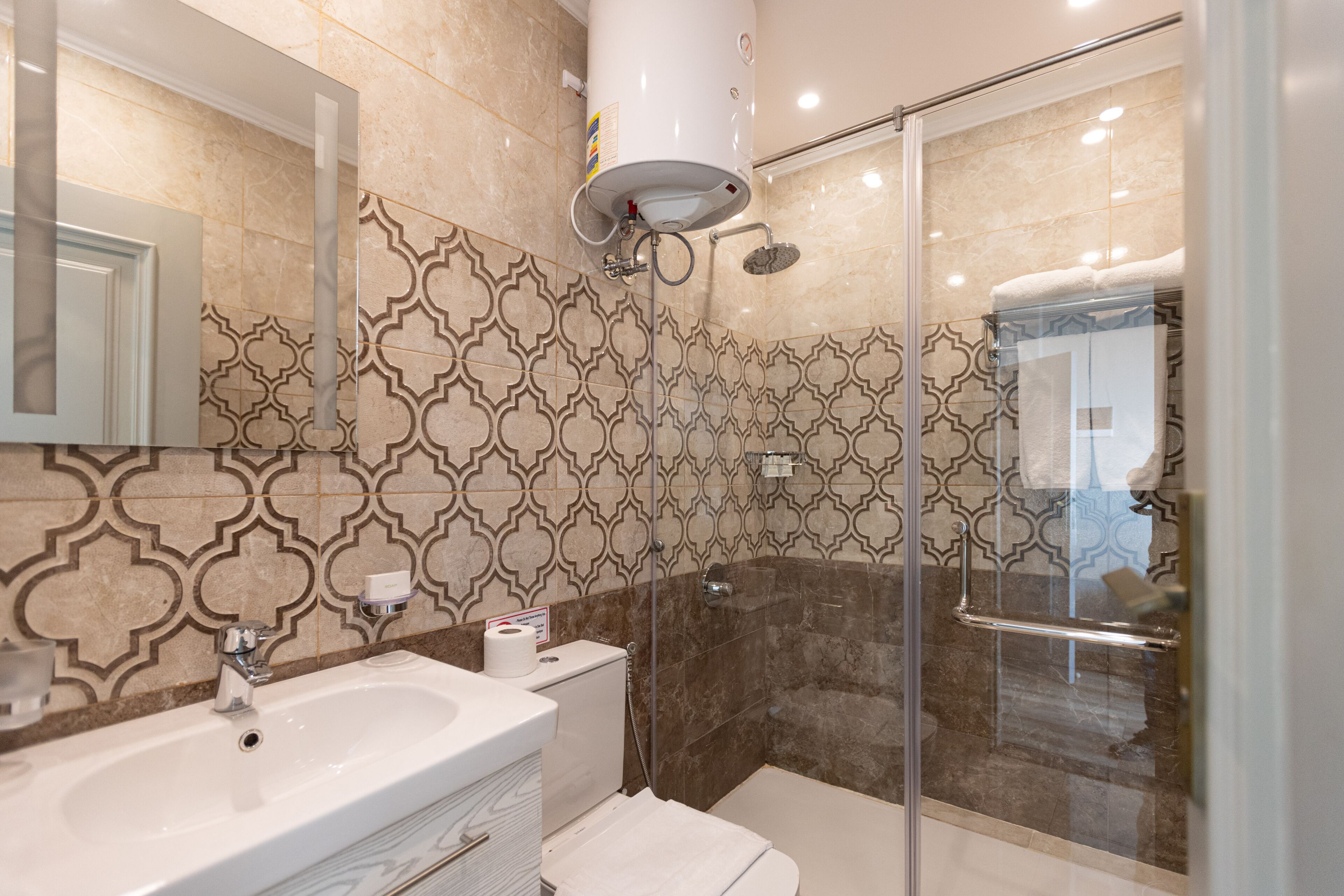 Une salle de bain moderne dotée d’un grand lavabo, de toilettes et d’un espace douche.