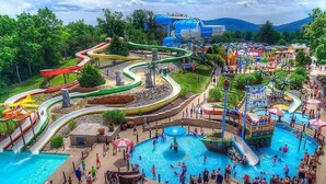 Un parc aquatique doté de nombreux toboggans et de plusieurs piscines, le tout entouré d’une végétation luxuriante.