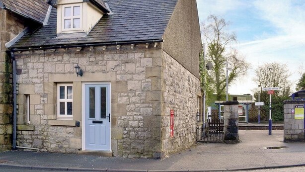 A stone building with a white door, a small window, and a chimney. - 2 bedroom accommodation in Silverdale (Silverdale)