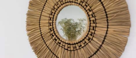 A circular wall hanging with concentric circles of straw-like material.