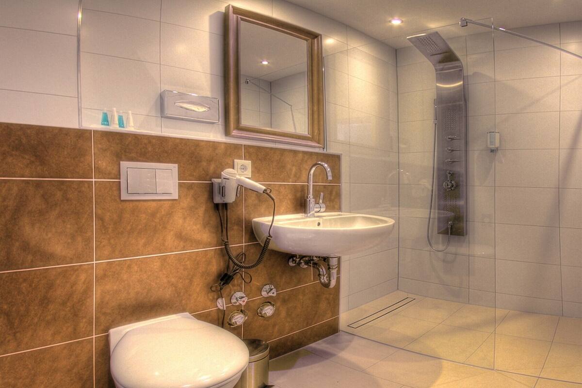 Un baño moderno con inodoro, lavamanos y ducha.