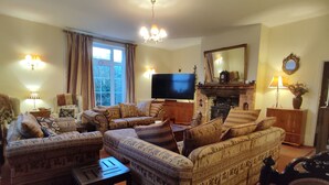 A traditional living room with patterned sofas, a television, and a fireplace. - The Cheese House (Salisbury)