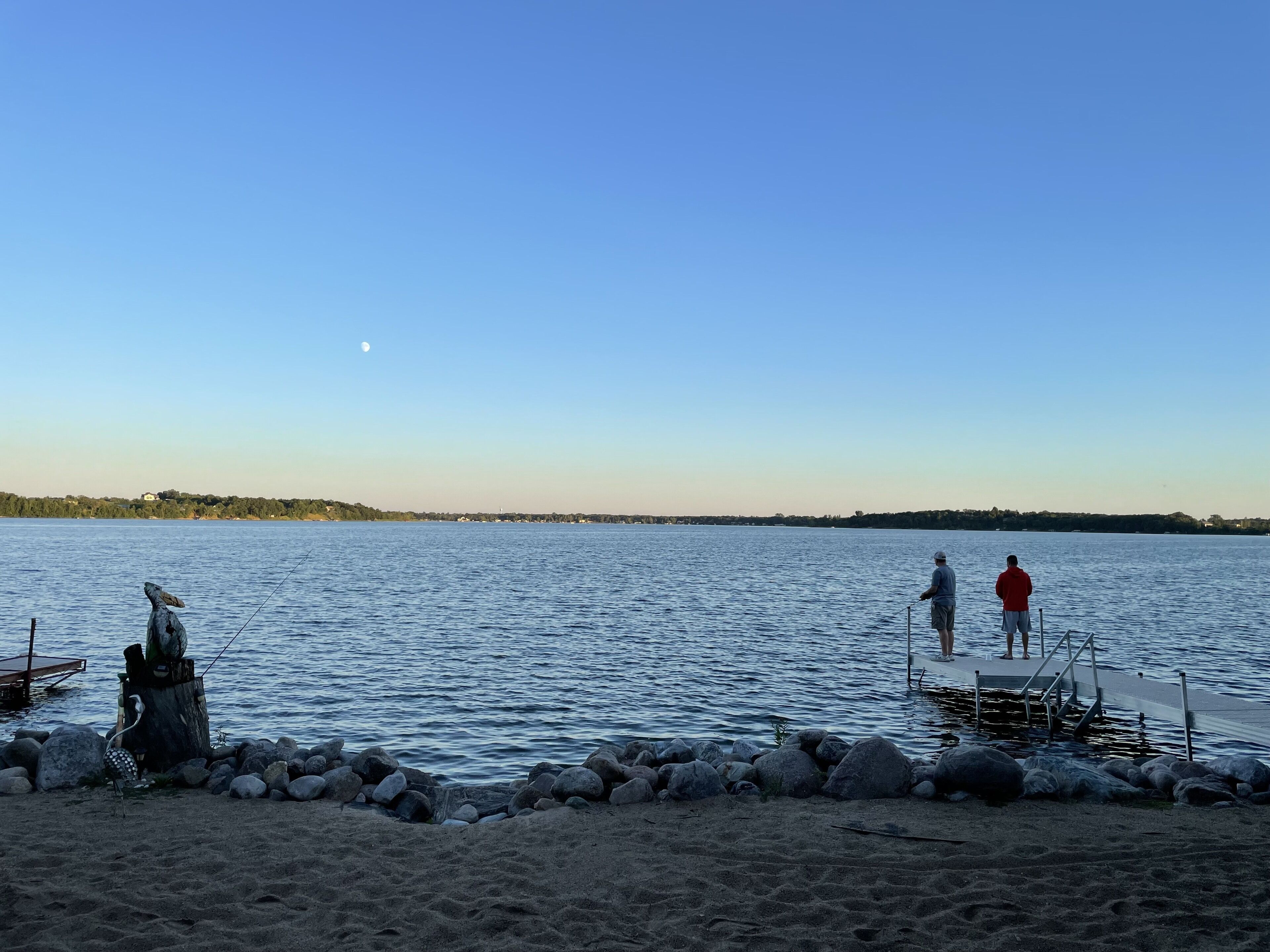 Ein ruhiger See mit einem Steg, der ins Wasser ragt.