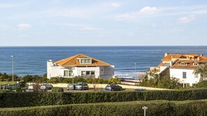 Una zona residenziale sulla costa, con case, cielo sereno e il mare sullo sfondo.