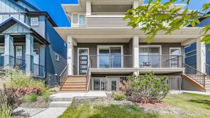 A two-story residential building with a balcony, a staircase, and a small garden area.