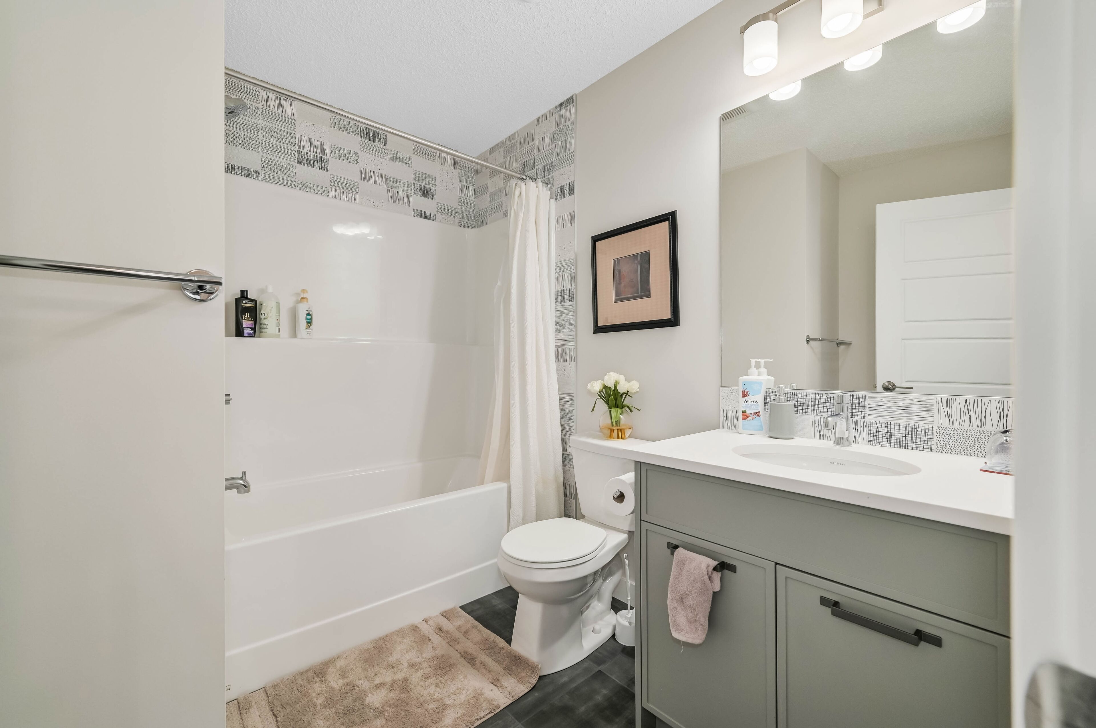 A modern bathroom with a bathtub, toilet, and vanity.