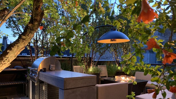 An outdoor patio with a grill, seating, and ambient lighting. - Luxe 3b/3b duplex w/ terrace, BBQ & parking. Near Kings Cross & central London. (London)
