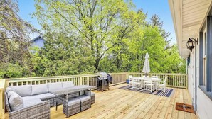 A wooden deck with outdoor furniture, including a sofa and a table, and a grill. - Walk to Shops & Dining – Renovated Gem (Sister Bay)