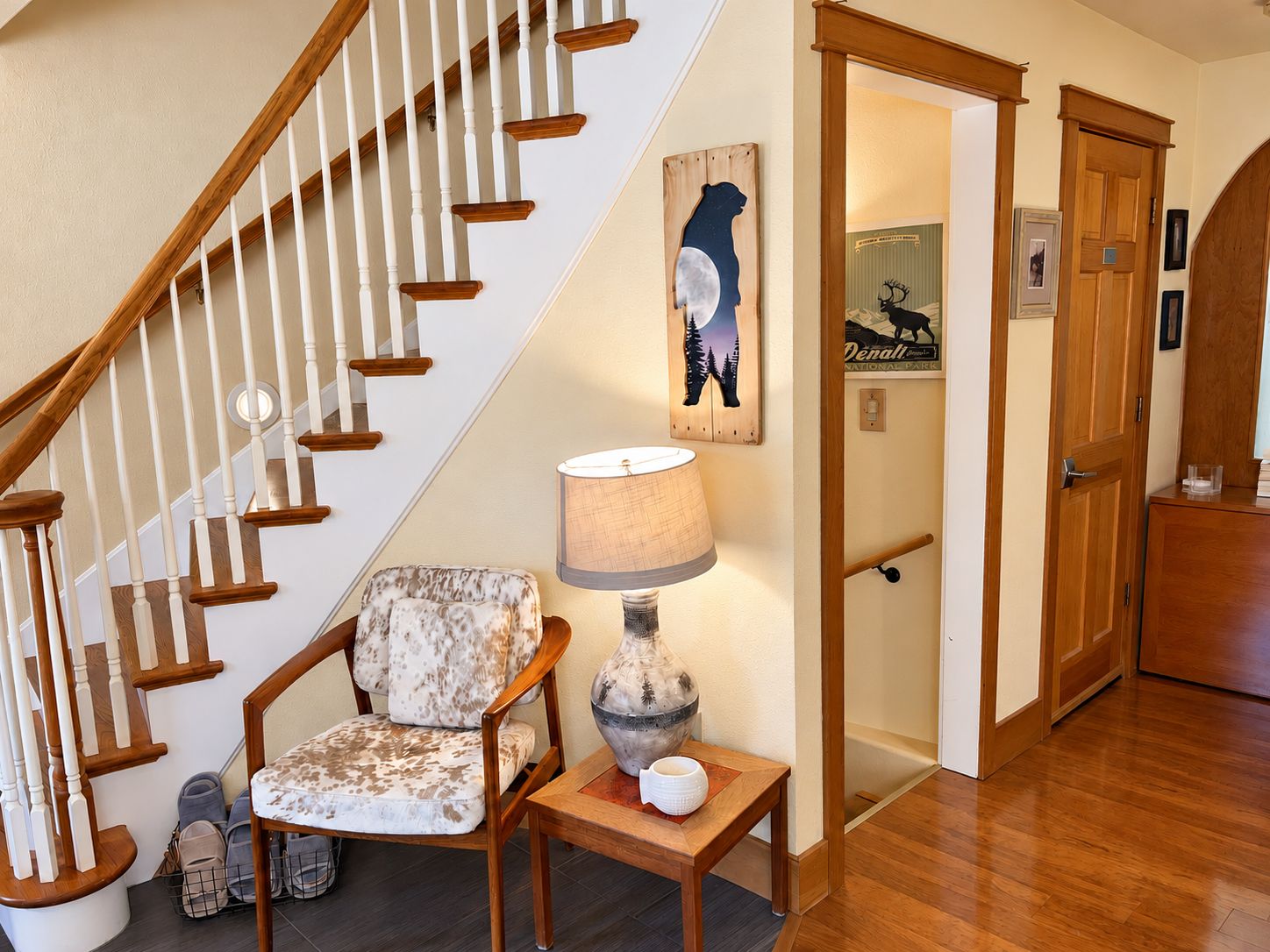A staircase with wooden balusters and a chair with a patterned cushion.