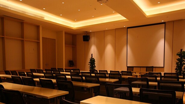 A conference room with rows of tables and chairs, a projector, and a screen. - Ji Hotel (shanghai Hongqiao International Exhibiti (Shanghai)