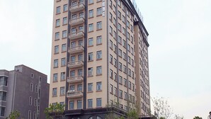 A multi-story hotel with a prominent sign at the top, balconies on the facade, and a uniform window pattern. - Ji Hotel (shanghai Hongqiao International Exhibiti (Shanghai)
