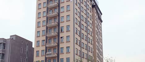 A multi-story hotel with a prominent sign at the top, balconies on the facade, and a uniform window pattern.
