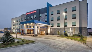Een modern hotel met een opvallende ingang, meerdere verdiepingen en een goed verlichte gevel.