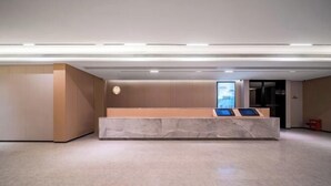 A reception desk with a marble top, a clock, and a digital display screen. - JI Hotel (Chongqing North Railway Station) (Chongqing)