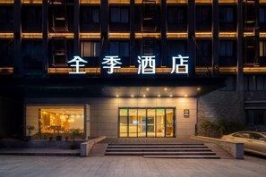 A hotel entrance with a signboard, a staircase leading to the entrance, and a car parked outside. - JI Hotel (Chongqing North Railway Station) (Chongqing)